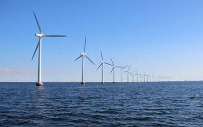 平靜的海面上佇立著一排風(fēng)力發(fā)電機(jī)，體現(xiàn)永磁材料在風(fēng)力發(fā)電領(lǐng)域的應(yīng)用