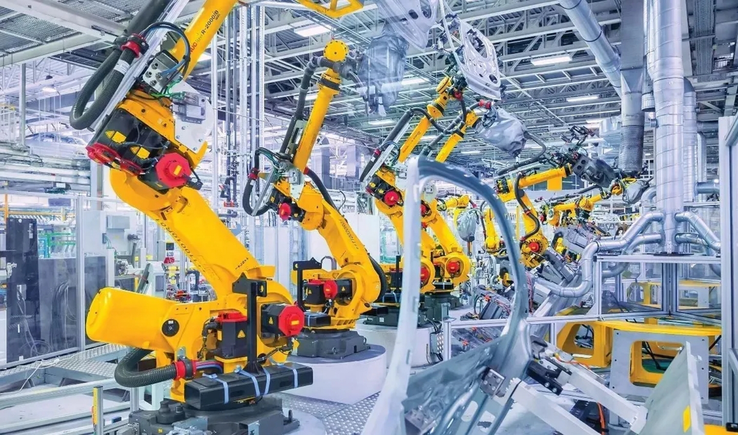 干凈明亮的現(xiàn)代化生產(chǎn)車間內(nèi)，明黃色的機(jī)器人排列整齊工作，表現(xiàn)永磁材料在工業(yè)自動(dòng)化行業(yè)的應(yīng)用